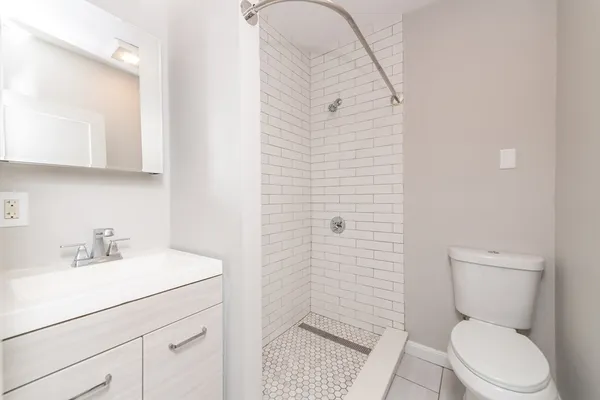 a bathroom with a sink a toilet and shower