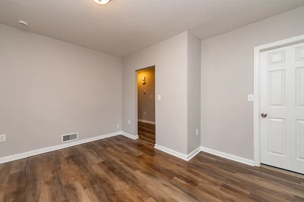 an empty room with wooden floor and closet