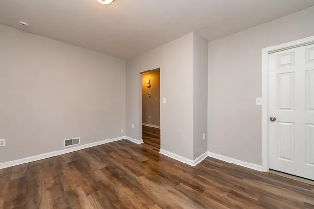 an empty room with wooden floor and closet