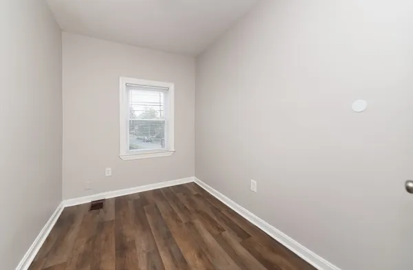 a view of a room with wooden floor and windows