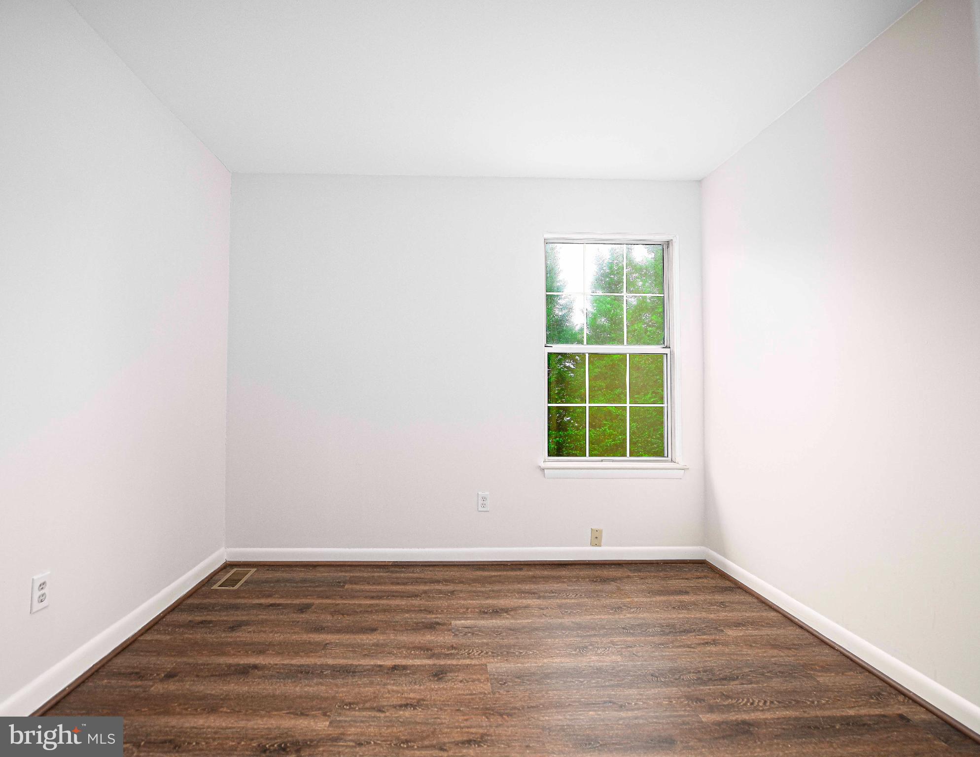 7105 Rutherford Green Circle Windsor Mill, MD 21244 - Photo 18 of 30 a view of an empty room with wooden floor and a window