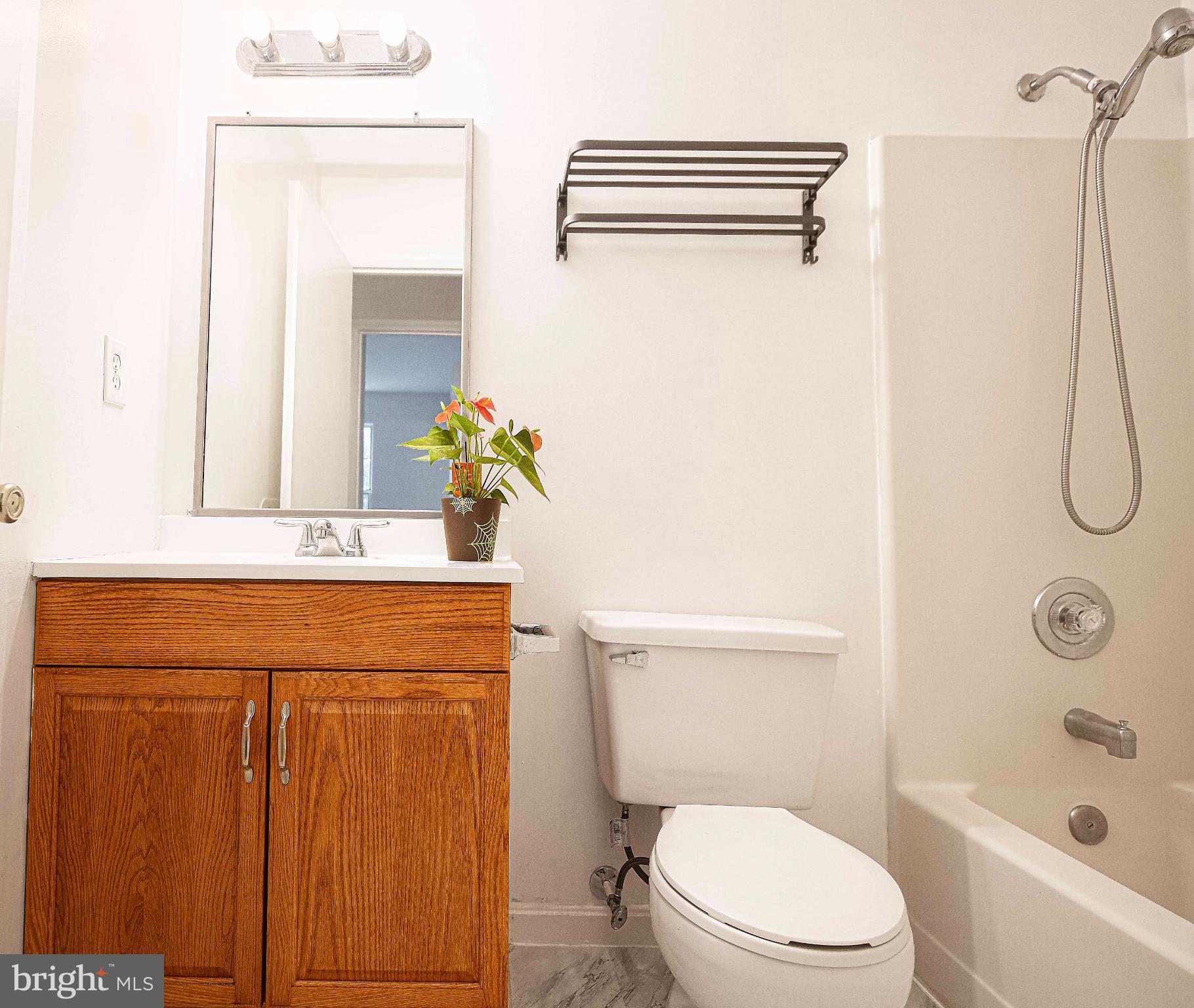 7105 Rutherford Green Circle Windsor Mill, MD 21244 - Photo 20 of 30 a bathroom with a granite countertop sink toilet and shower