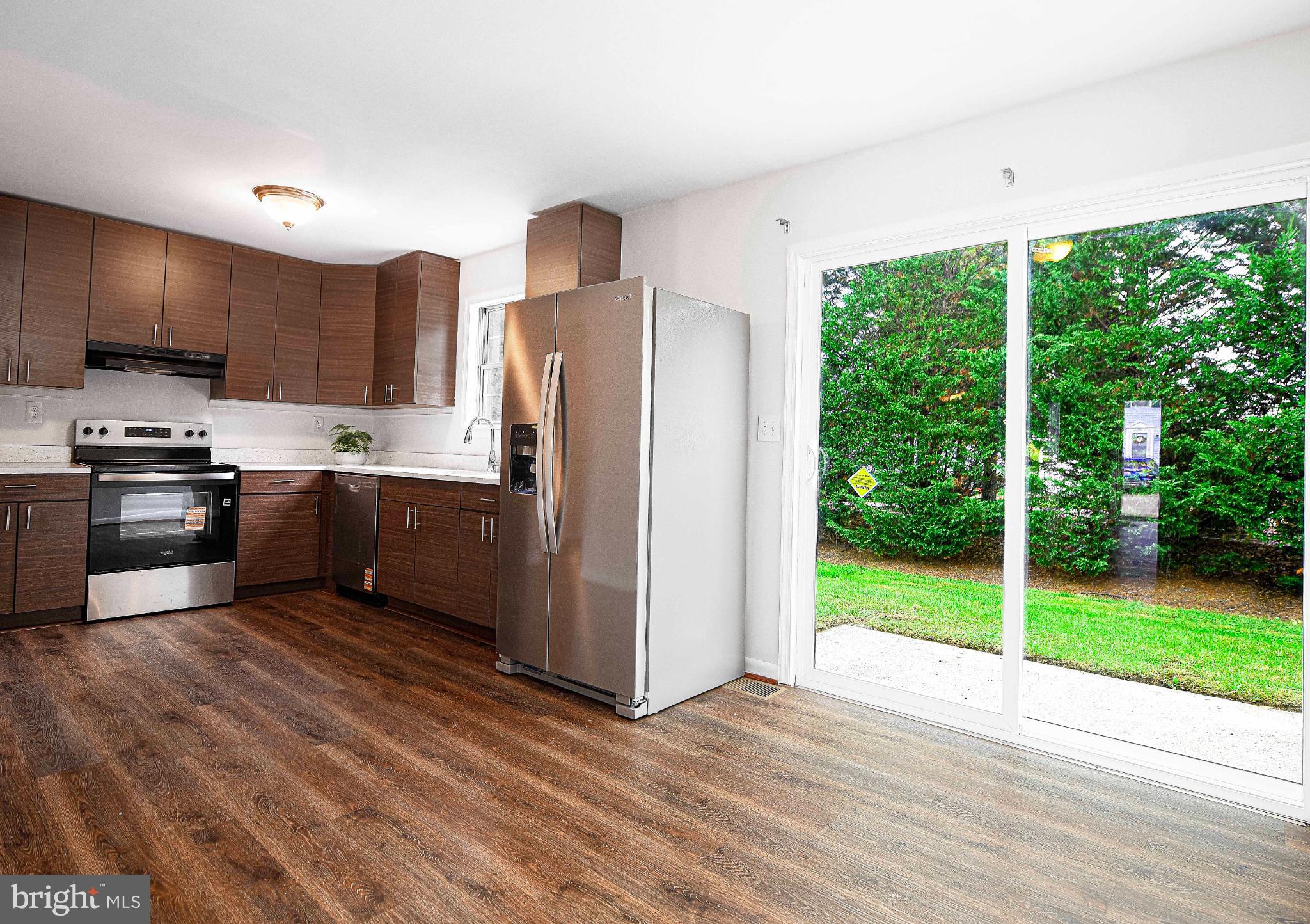 7105 Rutherford Green Circle Windsor Mill, MD 21244 - Photo 8 of 30 a kitchen with stainless steel appliances granite countertop a refrigerator a sink dishwasher a stove and a oven with wooden floor