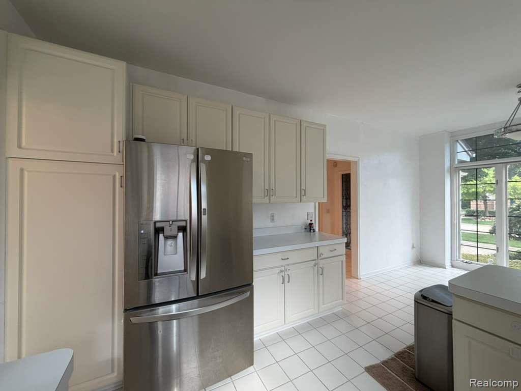 1154 Bluebird Drive Rochester, MI 48307 - Photo 13 of 34 Kitchen featuring a stainless steel French door refrigerator, white cabinetry, light-toned countertops, white square tile flooring, and large windows