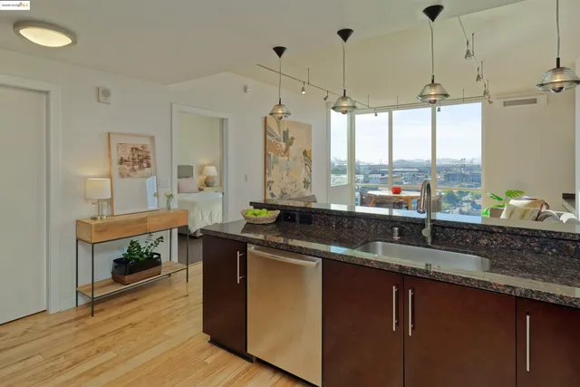 a kitchen with stainless steel appliances granite countertop a sink a stove and a wooden floor