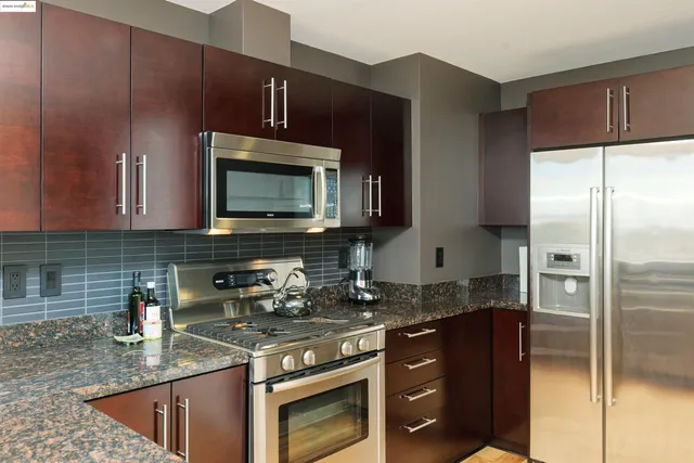 a kitchen with stainless steel appliances granite countertop a sink stove and refrigerator