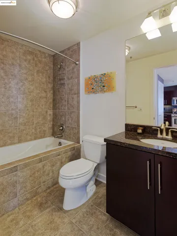 a bathroom with a granite countertop toilet sink and mirror