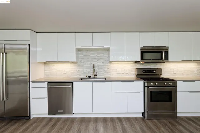 a kitchen with stainless steel appliances granite countertop a stove and a refrigerator