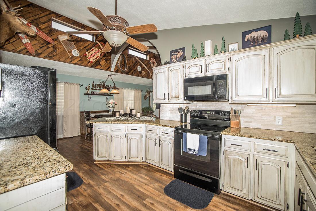 303 Cedar Fritch, TX 79036 - Photo 18 of 44 a kitchen with stainless steel appliances granite countertop a stove and cabinets