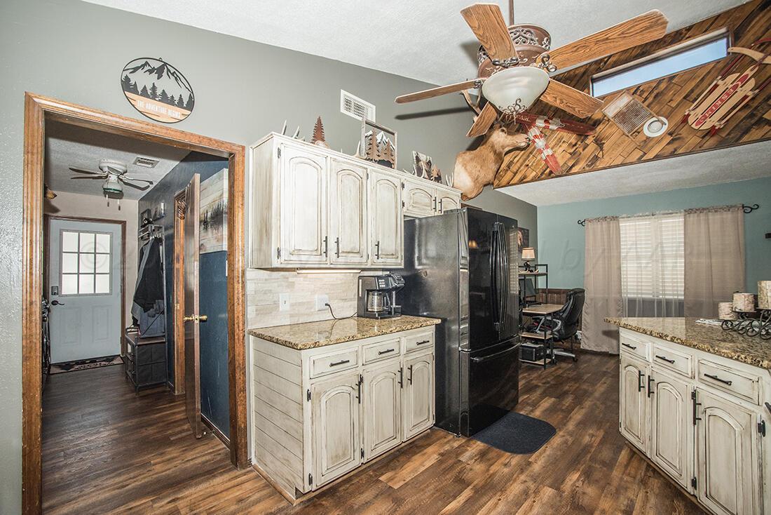303 Cedar Fritch, TX 79036 - Photo 19 of 44 a kitchen with a sink dishwasher a refrigerator and wooden cabinets