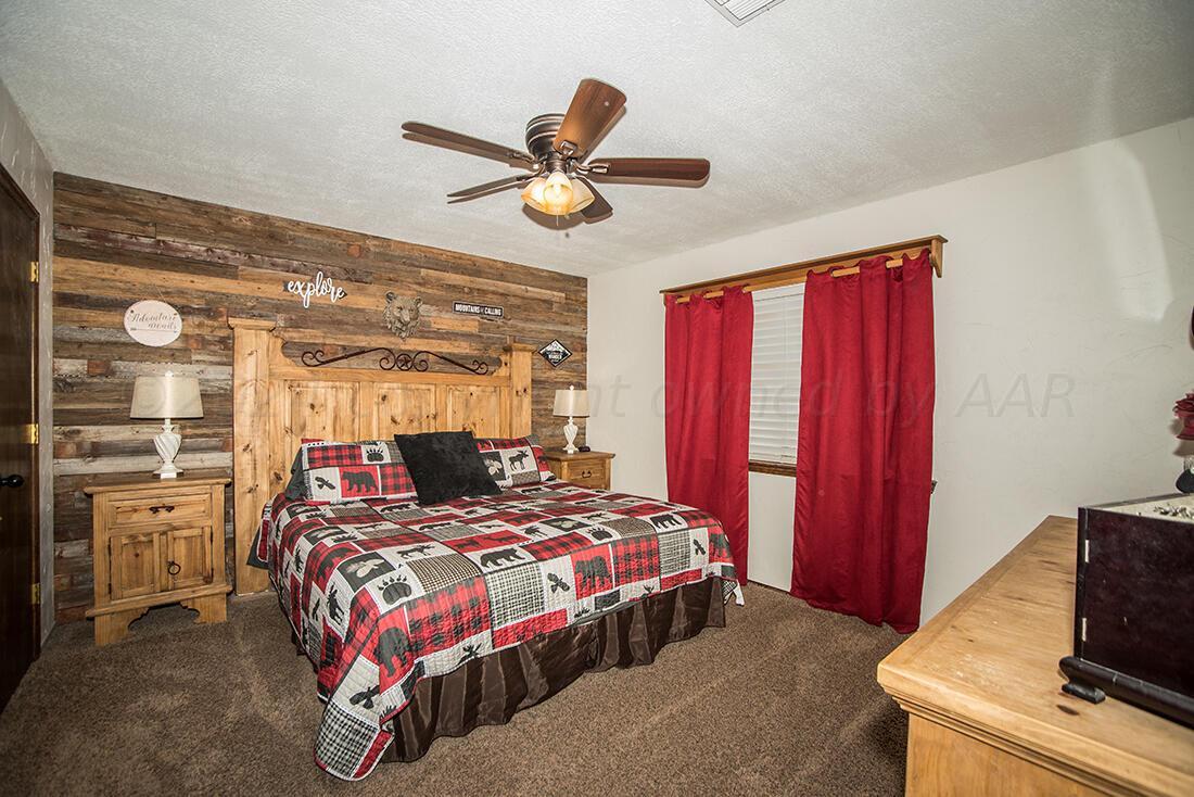 303 Cedar Fritch, TX 79036 - Photo 22 of 44 a bedroom with a bed and a chandelier
