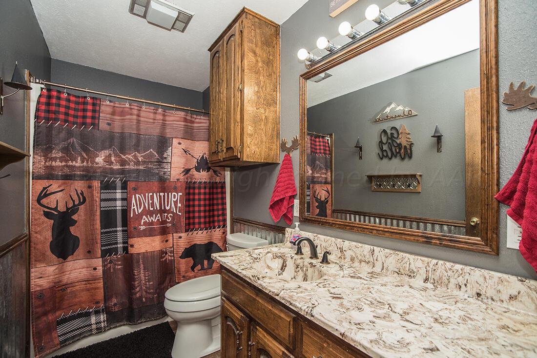 303 Cedar Fritch, TX 79036 - Photo 27 of 44 a bathroom with a sink vanity mirror and toilet