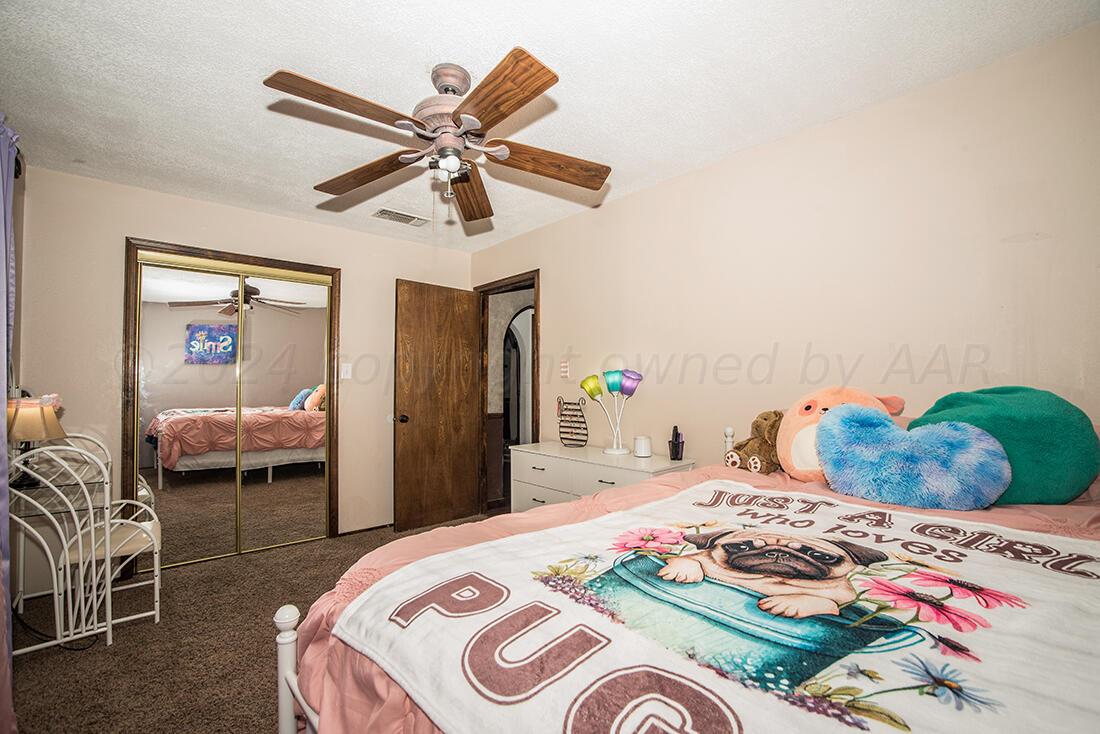 303 Cedar Fritch, TX 79036 - Photo 28 of 44 a bedroom with a bed and ceiling fan