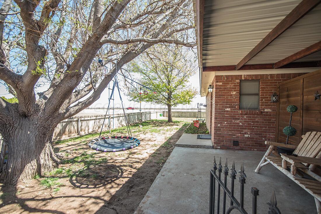 303 Cedar Fritch, TX 79036 - Photo 8 of 44 a view of a patio with table and chairs and wooden fence