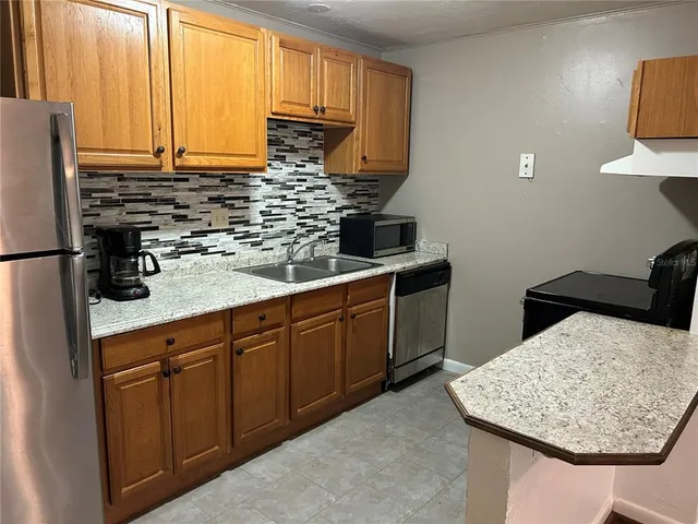 a kitchen with stainless steel appliances a sink dishwasher stove refrigerator and microwave