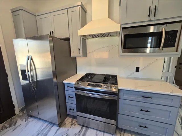 a kitchen with stainless steel appliances a stove a microwave and a refrigerator