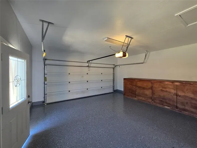 an empty room with wooden floor cabinet and windows