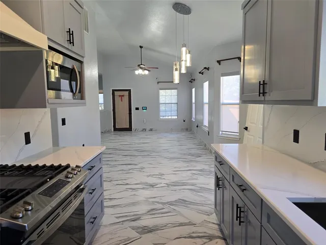 a kitchen with stainless steel appliances granite countertop a sink stove and refrigerator