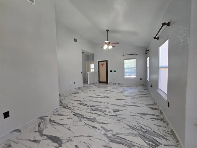 a view of a hallway with wooden floor and chandelier