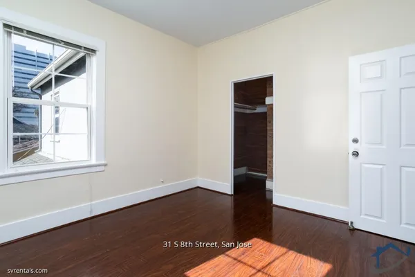 an empty room with wooden floor and closet