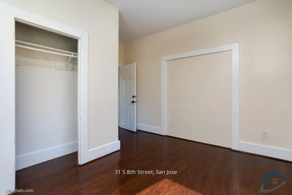 an empty room with wooden floor and closet