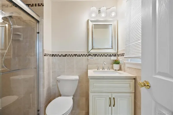 a bathroom with a toilet sink vanity and mirror