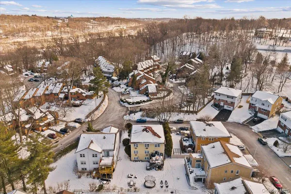 with white couches sitting next to a white wall and a large tree