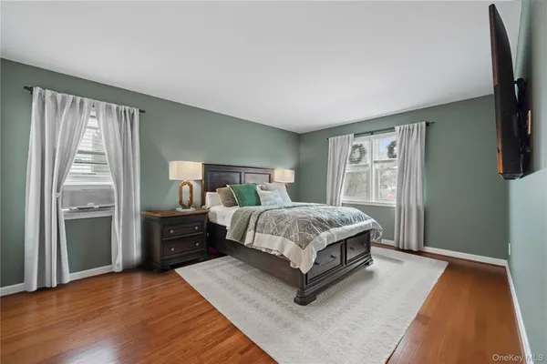a bedroom with a bed and a flat tv screen on dresser