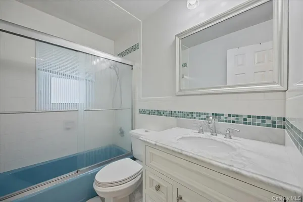 a bathroom with a granite countertop sink a toilet and shower