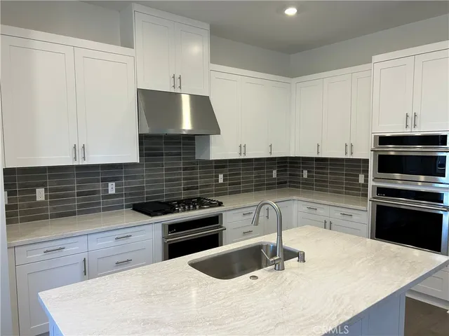 a kitchen with granite countertop a stove and a sink