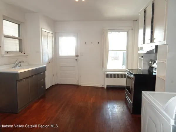 a kitchen with a sink wooden floor and a window