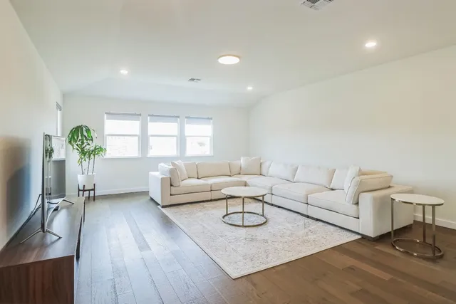 a living room with furniture and a wooden floor