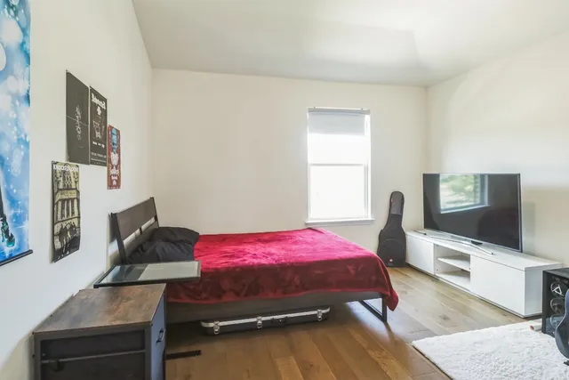 a bedroom with a bed and wooden floor