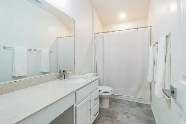 a bathroom with a double vanity sink toilet and a mirror