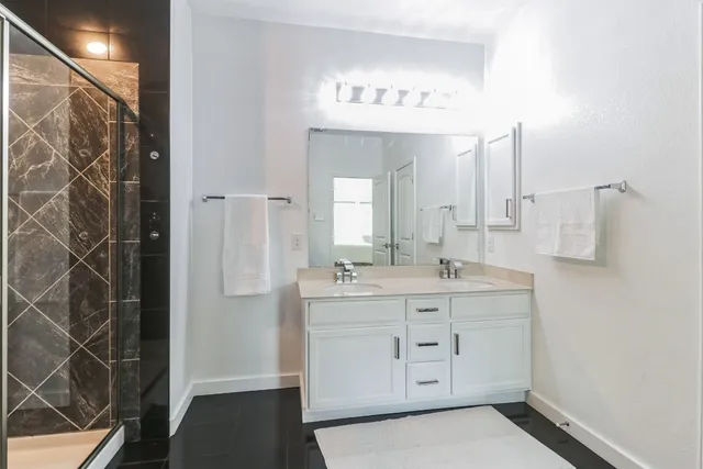 a bathroom with a double vanity sink a toilet and a mirror