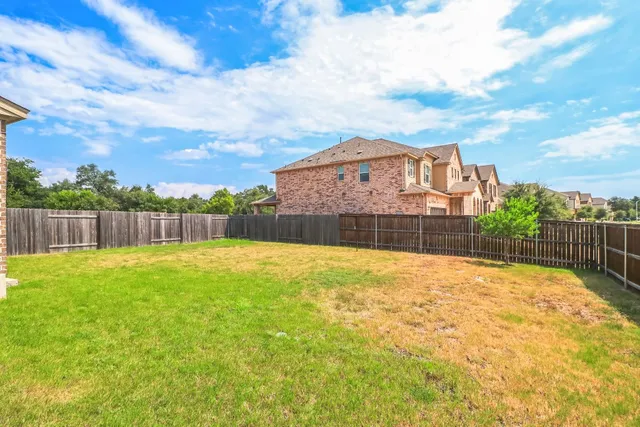 a view of a swimming pool with a yard and wooden fence
