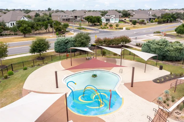 an aerial view of a swimming pool with outdoor seating