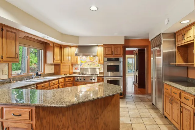 a kitchen with stainless steel appliances granite countertop a stove sink and microwave