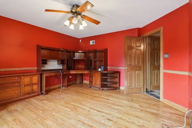an empty room with a window and a fan