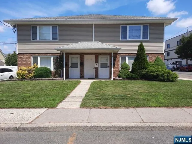 a front view of a house with a garden and plants