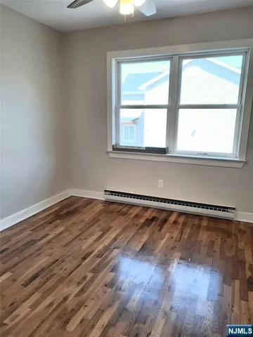 an empty room with wooden floor and closet
