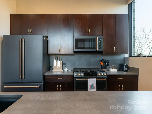 a kitchen with stainless steel appliances granite countertop a refrigerator and a stove top oven