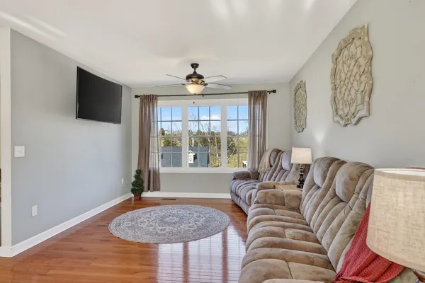 a living room with furniture a flat screen tv and a large window