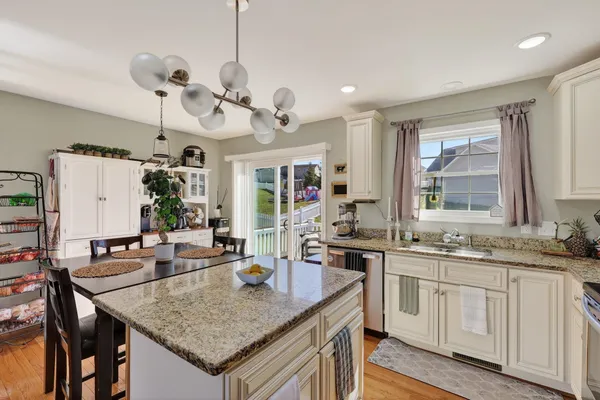 a kitchen with a stove a sink a dining table and chairs