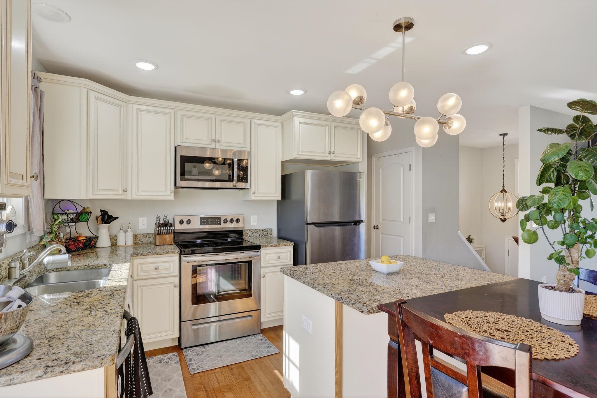 235 Locustdale Loop Shenandoah, VA 22849 - Photo 13 of 30 a kitchen with kitchen island granite countertop stainless steel appliances a sink a stove cabinets dining table and chairs