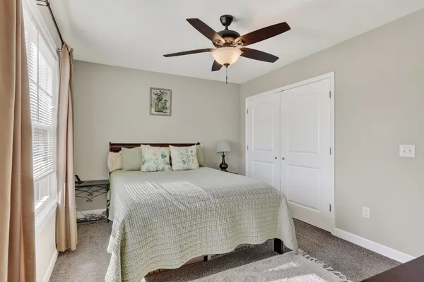 a bedroom with a bed and a large mirror with a wooden floor