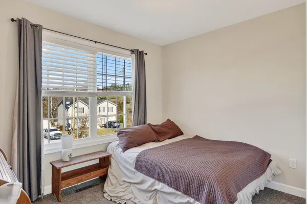 a bedroom with a bed and a large window