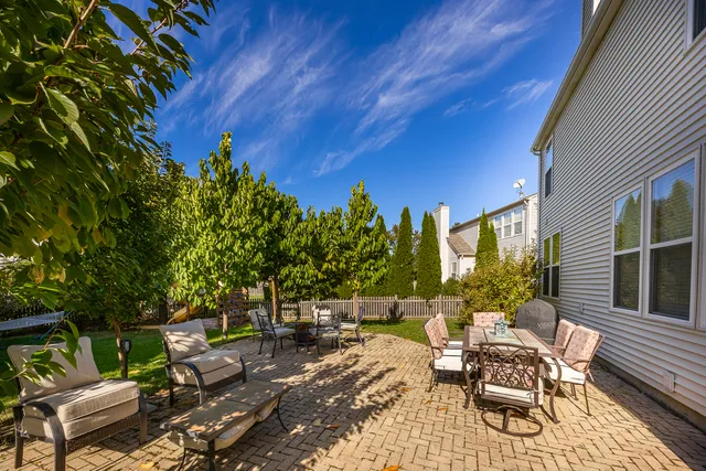 a view of a patio with a dining table and chairs with wooden floor and fence