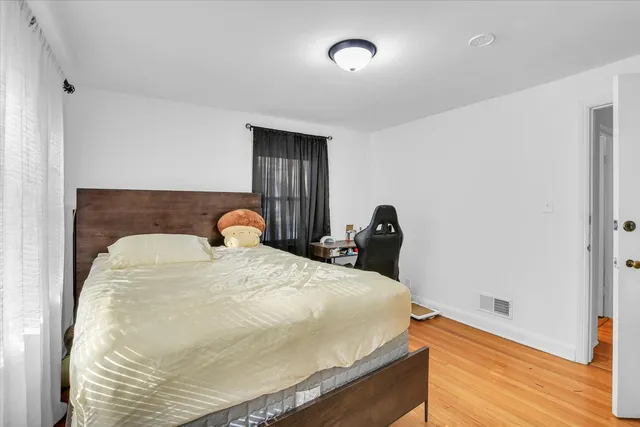 a bedroom with a bed and wooden floor