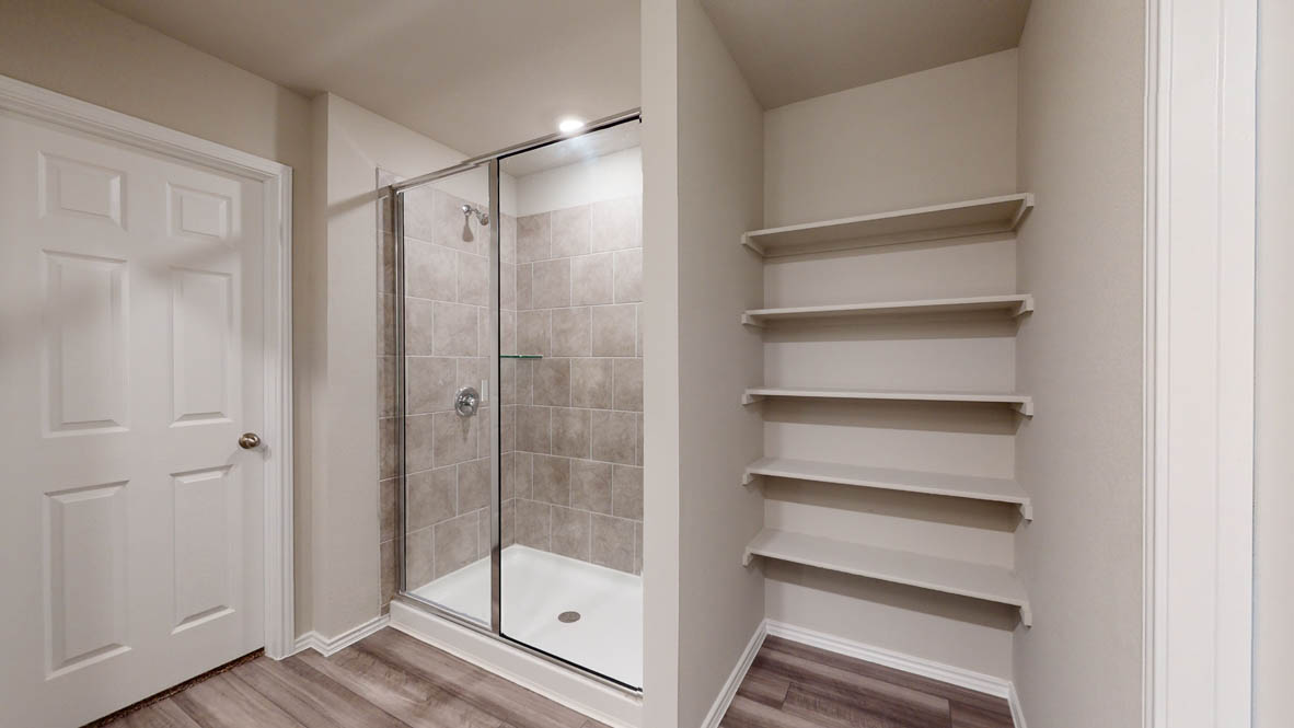513 Hector Loop Georgetown, TX 78626 - Photo 7 of 12 A streamlined shower enclosure and integrated shelving create a highly functional bathroom.